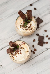 Iced Mocha Frappe Coffee with Whip Cream, Summer Drinking times. Coffee Beans. rustic textured Wooden Background. Mint Leaves