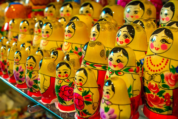 Fototapeta na wymiar Souvenir dolls on the shelf for sale. Russian Matryoshka Nesting Dolls Set in Classic Clothes at Gift Shop Shelf. Souvenir from Russia.