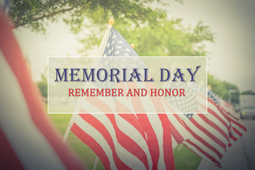Text Memorial Day and Honor on long row of lawn American Flags background. Green grass yard USA...