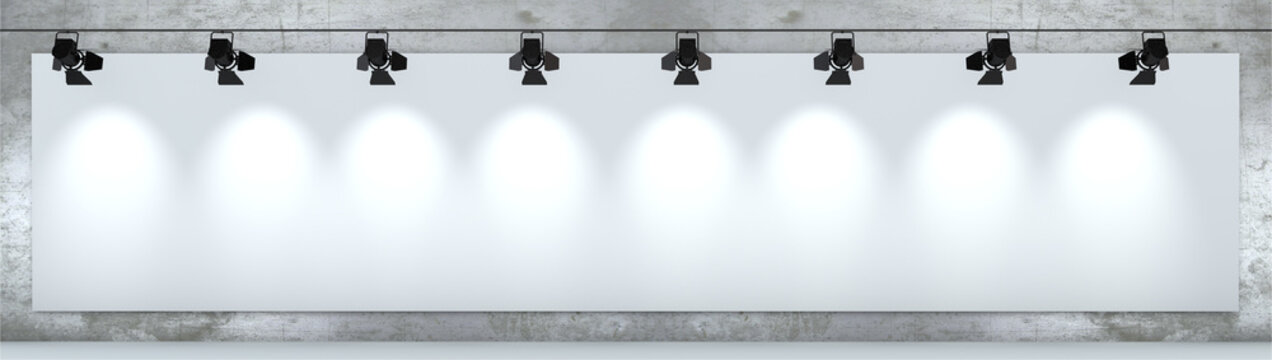 Cartellone pubblicitario bianco, illuminato da faretti appeso ad un muro