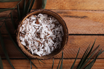 fresh natural coconut shavings, palm leaves, half coconut on the background of wood. 