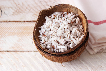 fresh natural coconut shavings, palm leaves, half coconut on the background of wood. 