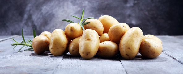 Pile of potatoes lying on wooden boards. Fresh potato