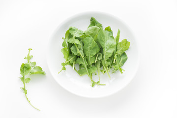 Rocket salad in white plate on isolated white background

