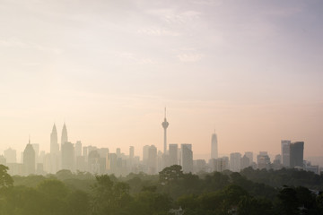 Fototapeta na wymiar beautiful view of Kuala Lumpur city skyline in the early morning with haze or fog and building is semi silhouette. tourism and cityscape concept