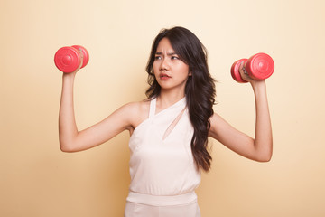 Exhausted Asian woman with dumbbells.