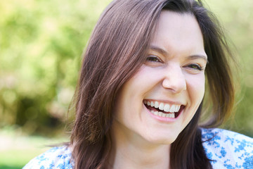 Fototapeta premium Outdoor Head And Shoulders Portrait Of Laughing Young Woman