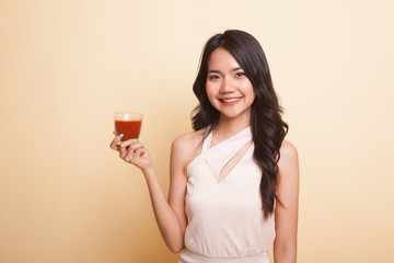 Young Asian woman drink tomato juice.