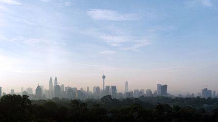Fototapeta na wymiar panorama view of beautiful kuala lumpur cityscape skyline in the hazy or foggy morning enviroment and buildings in silhouette with copy space