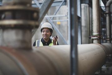 Female industrial worker using radio on site