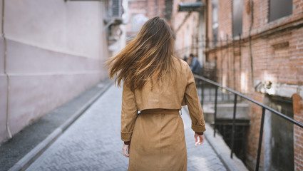 Portrait of a brunette girl in cloak. View from back.
