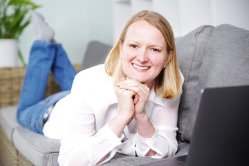 Frau mit Laptop auf der Couch 