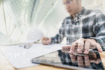 Engineer or Architech hand touching computer tablet interface with building design reality virtual technology at modern office on site. Building automation digital wireless control concept.