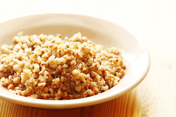 Buckwheat in a plate on a wood background