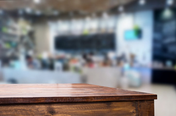 Selected focus empty brown wooden table and Coffee shop or restaurant blur background with bokeh image. for your photomontage or product display.