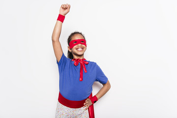 Portrait of girl in superhero costume against grey background