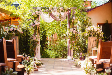 Fototapeta na wymiar Wedding decoration ceremony. Arch of flowers on the summer area of the restaurant