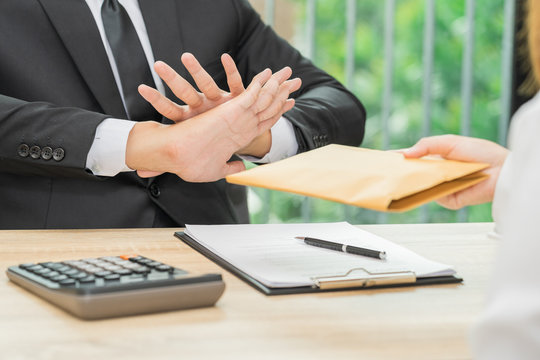 Businessman rejecting money in envelope offered by a woman - corruption concepts