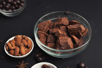 Crushed chocolate pieces in bowl on black background