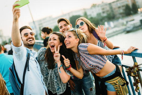 Happy young friends taking selfie on street