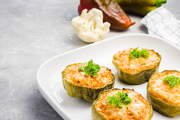 Vegetarian lasagna stuffed peppers in baking dish on light concrete background. Selective focus, copy space.