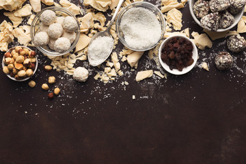 Crushed white chocolate pieces and truffles on dark background
