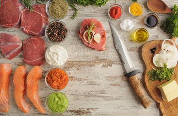 Sous vide. Beef, salmon, spice, greens on wooden table top as ingredients for cooking at low temperatures.