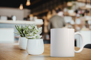 White coffee Mug Mockup set-up in a cafe, next to cactus plants and with blurred background. Great...