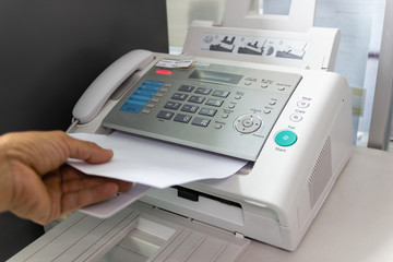 Hand Man are using a fax machine in the office. Business concept 