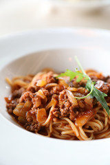 spaghetti Bolognese with minced beef and tomato sauce garnished with parmesan cheese and basil , Italian food