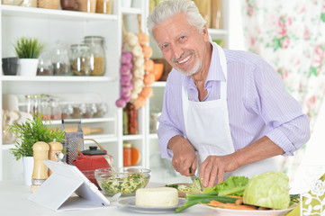 Senior man  preparing dinner in kitchen