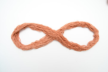 Yarn rope shaped as an infinity sign, isolated on white background