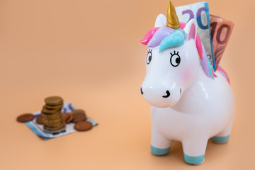 Buntes Einhorn mit Kleingeld und goldenem Horn