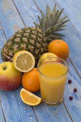 orange juice with fruit on a blue wooden background. 