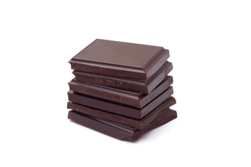 Stack of dark chocolate pieces isolated on white