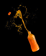 Orange juice up from a plastic bottle on a black background,orange juice splash
