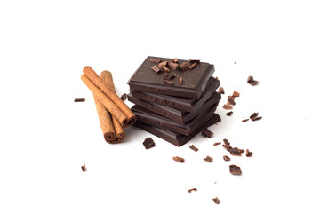 Stack of dark chocolate pieces and cinnamon, isolated on white