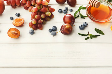 Naklejka na ściany i meble Fresh fruits and berries border on white wood top view
