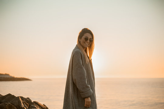 Portrait of woman wearing sunglasses and winter coat looking at camera smiling, side view, Odessa, Odeska Oblast, Ukraine, Eastern Europe