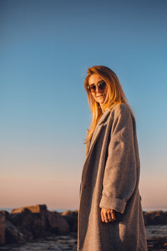 Portrait of woman wearing sunglasses and winter coat looking at camera smiling, side view, Odessa, Odeska Oblast, Ukraine, Eastern Europe