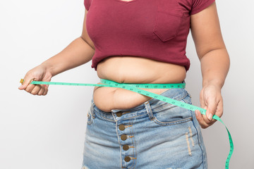 Overweight woman check out his body fat with green measuring tape for obesity on gray background, Healthy concept