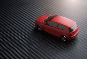 Red miniature car on carbon kevlar