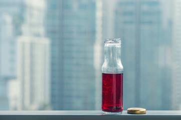 Pomegranate cold juice in bottles opposite the metropolis and skyscrapers