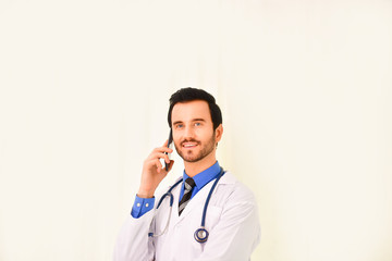 Fototapeta premium Smiling doctor posing in the office, he is wearing a stethoscope, medical staff on the hospital background