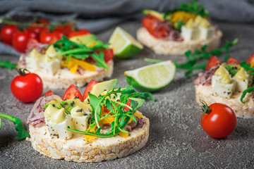 Bruschetta with tomato, avocado, herbs and arugula. Rustic background. Top view