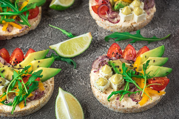Bruschetta with tomato, avocado, herbs and arugula. Rustic background. Top view