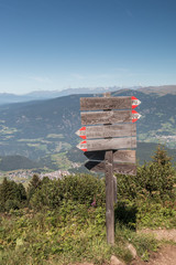 Wegweiser in Südtirol auf der Seiser Alm mit Blick auf Kastelruth, Italien