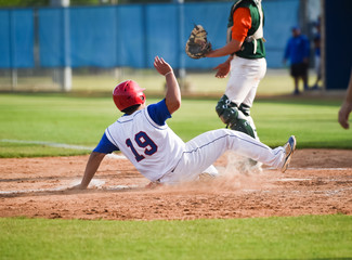 Baseball player sliding into the base during a game