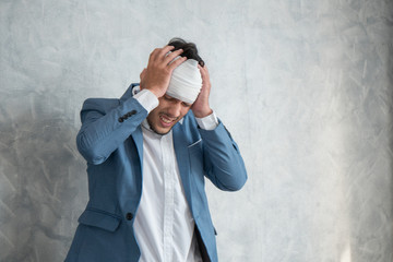 Sick business man touching his head with hands after working hard at office