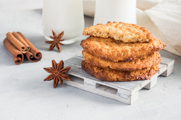 Fresh healthy milk and oatmeal cookies with cereals on grey concrete background